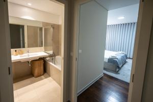a bathroom with a sink and a bed in a room at Funchal Next Corner Plaza in Funchal +152 photos