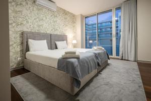 a bedroom with a large bed and a large window at Funchal Next Corner Plaza in Funchal