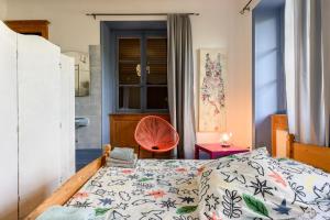 a bedroom with a bed and a chair and a window at Appartement Cadichon in Munster