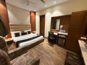 a hotel room with a bed and a television at my divine hotel in Amritsar +3 photos