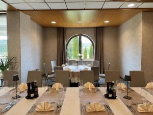 een vergaderruimte met tafels en stoelen en een groot raam bij Hotel Venko in Dobrovo