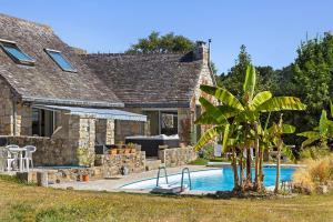 a house with a swimming pool and a palm tree at Maison Bringwiller Plage 200m in Trégastel