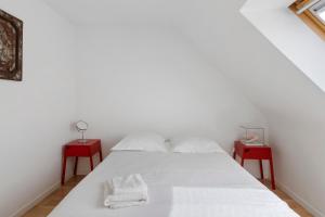 a white bed with two red end tables at Maison Bringwiller Plage 200m in Trégastel +31 photos