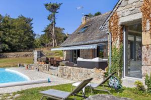 a stone house with a swimming pool and patio at Maison Bringwiller Plage 200m in Trégastel
