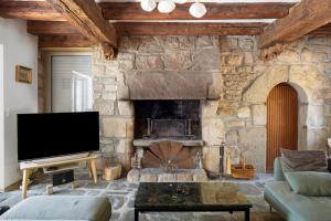 a living room with a stone fireplace and a tv at Maison Bringwiller Plage 200m in Trégastel