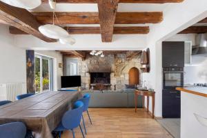 a kitchen and living room with a wooden table and blue chairs at Maison Bringwiller Plage 200m in Trégastel