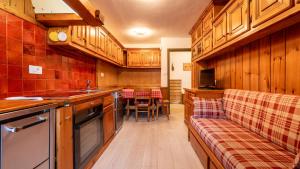 a kitchen with wooden cabinets and a couch at Casa Amabile in Cortina dʼAmpezzo