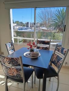 a blue table and chairs in a room with a window at El Depto de Roberto in Villa María
