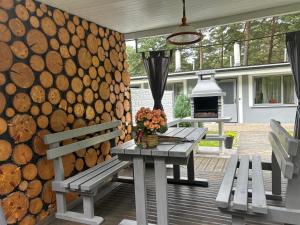 a patio with two benches and a table with flowers at Silumetras in Ventspils
