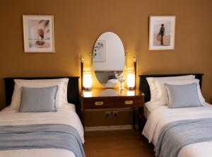 a bedroom with two beds with a mirror and a dresser at Spacious Frankston Retreat in Frankston