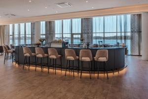 a bar in a hotel lobby with stools at Monumenti Heritage Hotel&Resort in Pula +107 photos