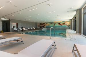 a swimming pool in a building with a painting on the wall at Monumenti Heritage Hotel&Resort in Pula