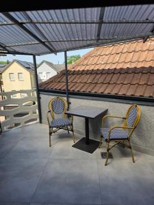a patio with two chairs and a table on a roof at Handwerkerwohnung, Monteurunterkunft-Rodgau in Rodgau