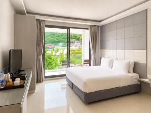 a bedroom with a bed and a large window at Sunset Beach Hotel - Adults Only in Haad Rin +63 photos