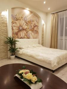Un dormitorio con una cama y una mesa con flores. en Lauvas Līcis, en Rūjiena
