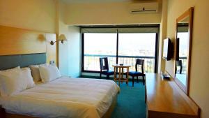 a hotel room with a bed and a table with chairs at Oakland Hotel in Rayfūn +29 photos