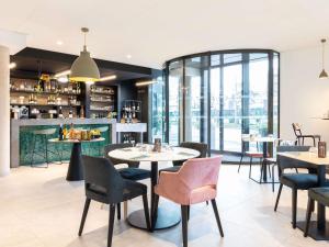 a restaurant with tables and chairs and a bar at ibis Styles Bezons Paris La Défense in Bezons
