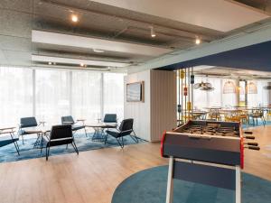 a room with tables and chairs and a pool table at ibis budget Morlaix in Morlaix