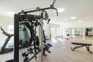 a room with a gym with treadmills and machines at FeWo Tommy in Zirchow