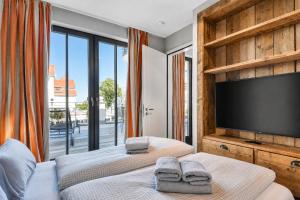 a bedroom with two beds and a flat screen tv at Ferienwohnung Strandperle in der Villa Martha Binz in Binz