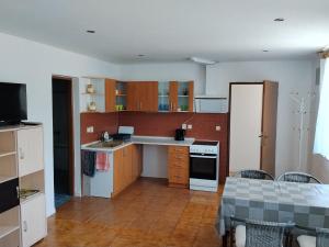 a kitchen with wooden cabinets and white appliances at Apartmán in Doubravice