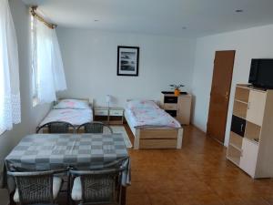 a room with two beds and a table and chairs at Apartmán in Doubravice