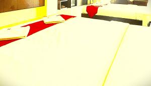 two beds in a room with white sheets at The B And D Hotel in Guwahati