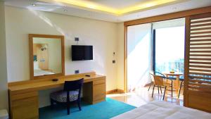 a bedroom with a desk with a mirror and a table at Oakland Hotel in Rayfūn