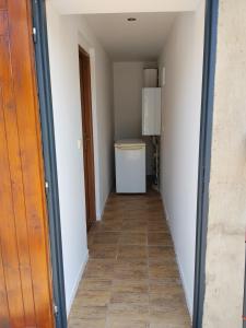 a hallway leading to a laundry room with a refrigerator at Apartmán in Doubravice +1 photo