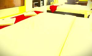 a bed with white sheets and red pillows on it at The B And D Hotel in Guwahati
