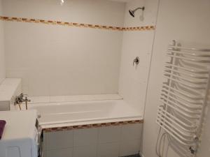 a white bathroom with a tub and a sink at Apartmán in Doubravice