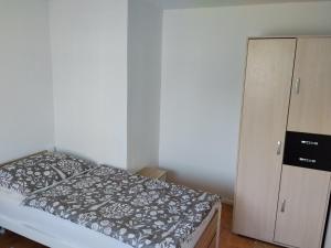 a small bedroom with a bed and a cabinet at Apartmán in Doubravice
