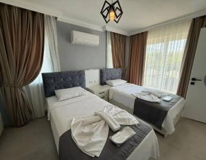 a hotel room with two beds and a window at Sever Apart in Gaziantep