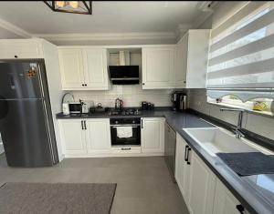 a kitchen with white cabinets and a stainless steel refrigerator at Sever Apart in Gaziantep