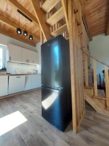 a black refrigerator in the middle of a kitchen at Świerkowy Las in Sanok