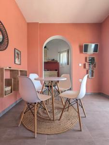 a dining room with orange walls and a table and chairs at Under The Palm Tree - Boutique Stay Experience in Áno Meriá