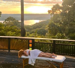 a woman laying on a bed on a bench on a deck at TerrAmor Ecoliving in Alter do Chao +37 photos