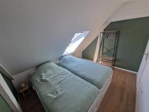 a small bedroom with a bed and a ladder at La maison des Hirondelles 2 in Fort-Mahon-Plage