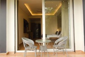 a glass table and chairs on a porch with a table and chairs at Cliffs & Clouds in Bhīm Tāl