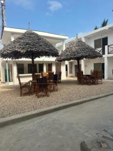 a group of tables and chairs under umbrellas at Spice Garden Lodge B&B in Zanzibar City