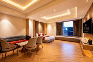a hotel room with a bed and a table and chairs at The Aura Hotel & Resort in Noida
