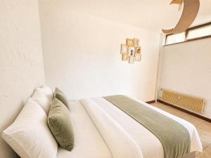 a bedroom with a white bed and a window at Refuge Gaillard Tramway in Gaillard