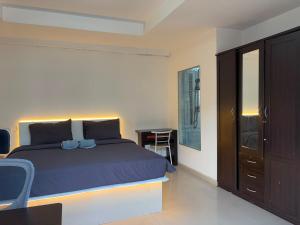 a bedroom with a blue bed and a desk at Lagoon vibes in Pattaya