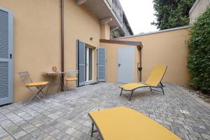 a patio with chairs and a table in a building at Casa Vacanze Regina in Lecco