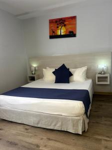 a bedroom with a large bed with blue and white sheets at Le Grand Hôtel de Thiès in Thiès +19 photos