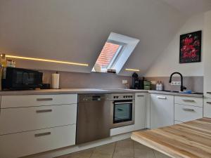 a kitchen with white cabinets and a stove and a window at Daheim in Burk in Burk
