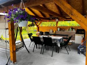 a table and chairs in a kitchen with a pot of flowers at Apartman UnaTesnim in Bihać