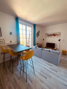 a living room with a table and chairs and a couch at Le Petit Condette in Condette