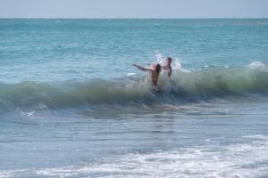a man riding a wave on a surfboard in the ocean at Mera Maris in Cap Aurora +70 photos