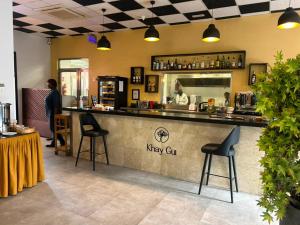 a bar in a restaurant with a person standing at a counter at Le Grand Hôtel de Thiès in Thiès